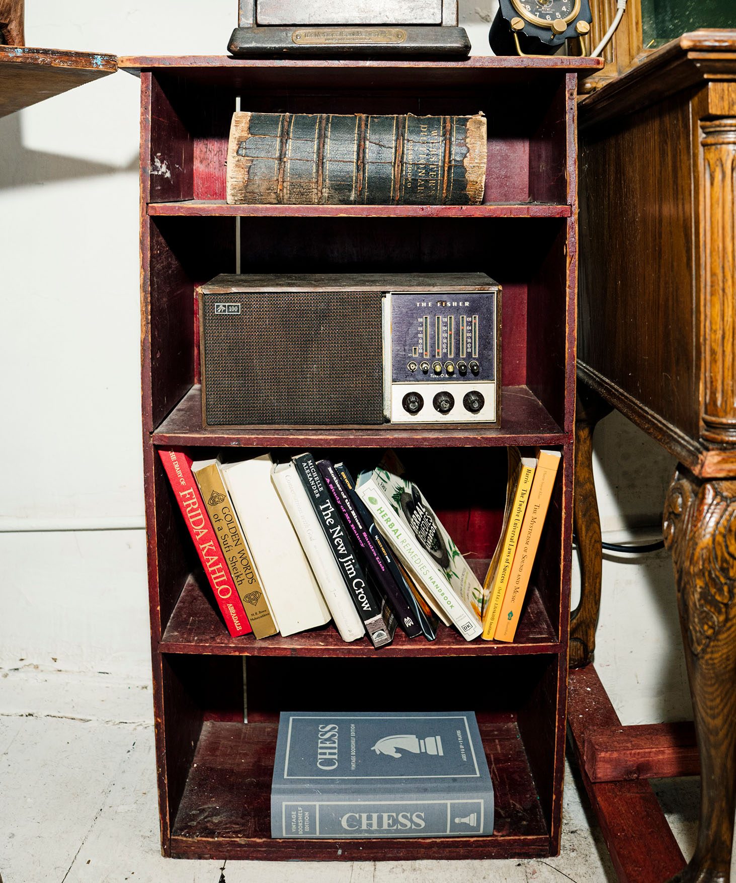 Detail of shelves with an antique cash register, an antique radio, and books