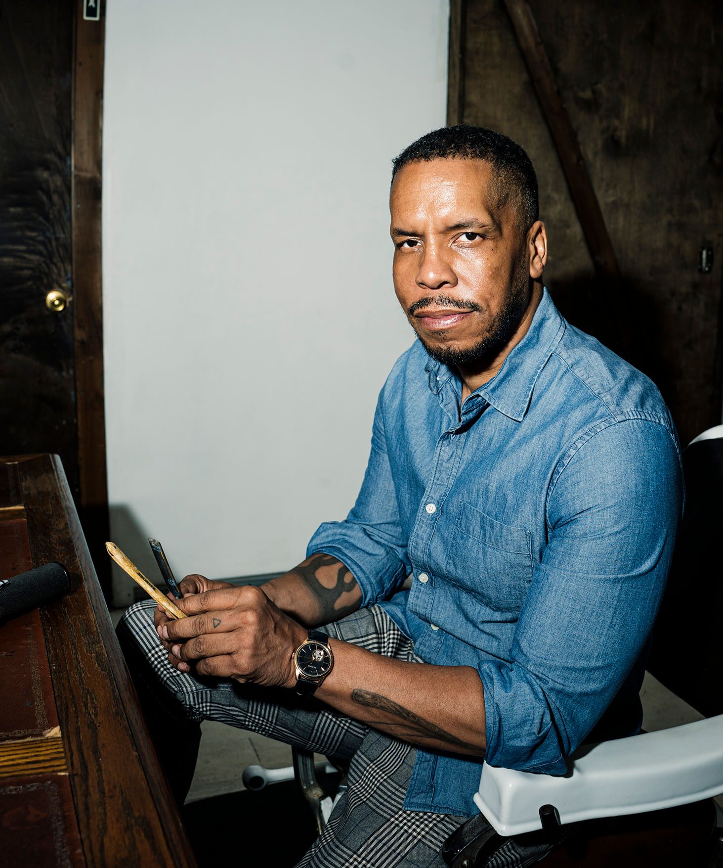 Gregory Purnell seated in a chair holding is barber's razor.