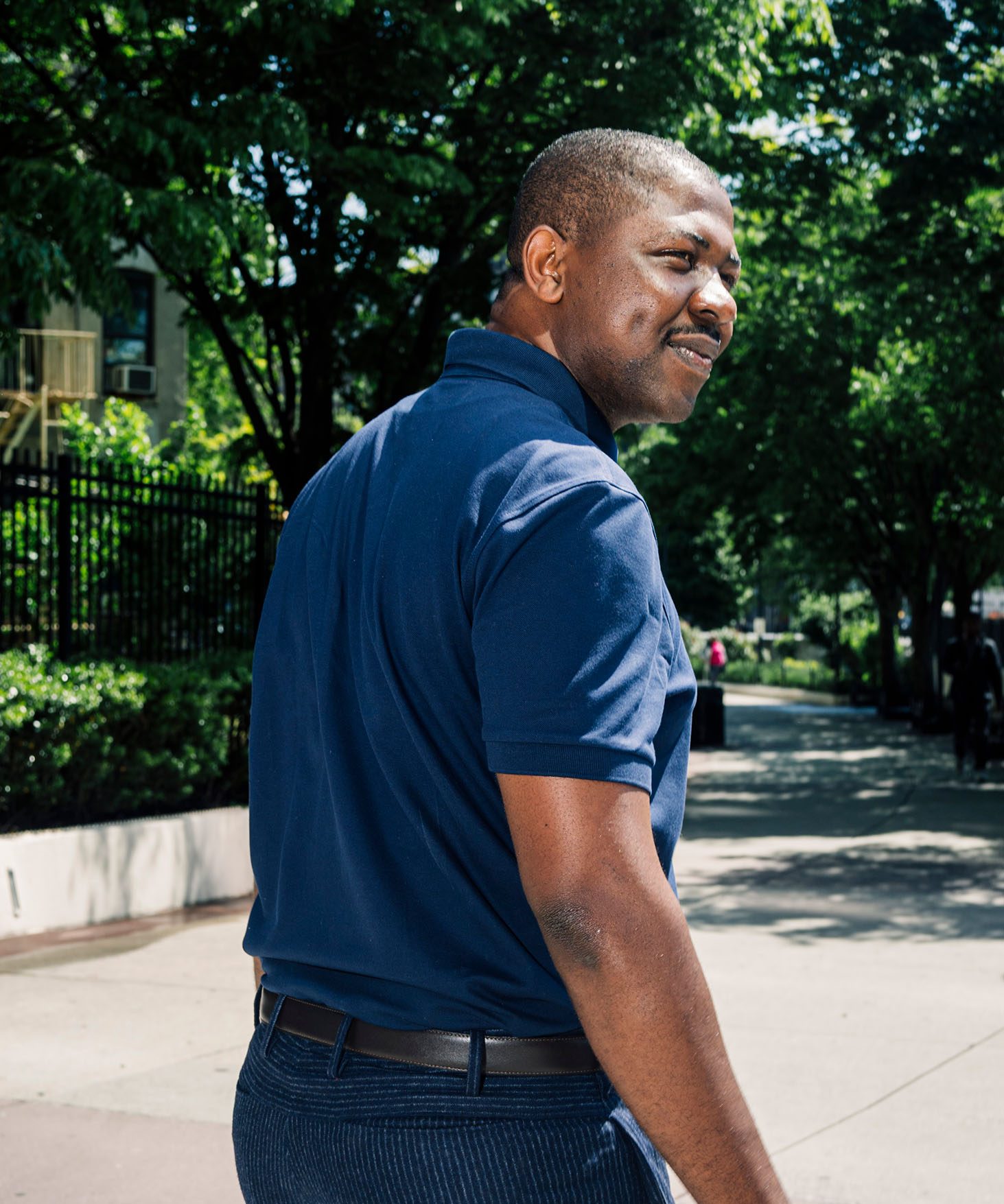 Edafe Okporo walking on a sidewalk, turning to the right.